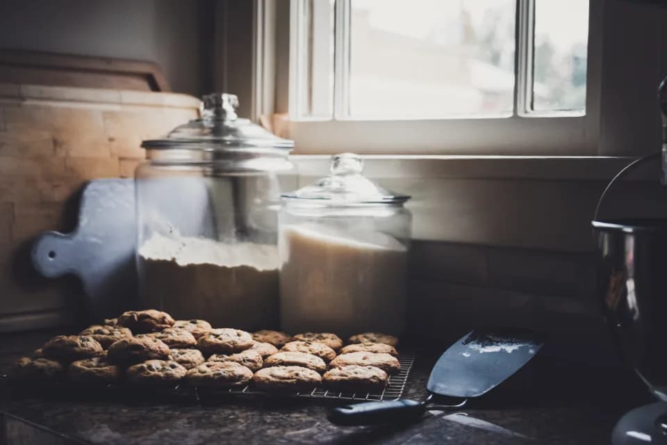 Galletas enfriándose en una rejilla junto a la ventana de la cocina